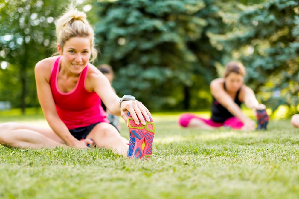 Portait of a blond girl getting streching her legs before running outdoors Portait of a blond girl getting streching her legs before running outdoors
